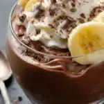Chocolate mousse & gourmet banana dessert topped with whipped cream and chocolate shavings in a glass