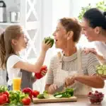 Three generations preparing vegetables together, promoting healthspan longevity through whole foods