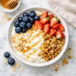 What Eric Topol Eats in a Day: Longevity Breakfast Bowl with Greek yogurt, blueberries, strawberries, granola, almonds, and honey drizzle